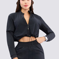 Chaqueta color negro, con cierre frontal, ajuste en la cintura y tacto suave.