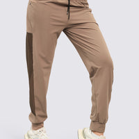 Jogger deportivo color mocca, de tiro alto, pretina ajustable, mallas laterales y bolsillos funcionales.