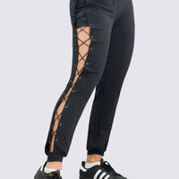 Jogger negro deportivo de diseño atrevido con aberturas laterales y sistema de cordones ajustables que aportan un look moderno y diferenciador.