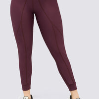 Leggings deportivo color vinotinto, tiro alto, con costuras del mismo tono, que estilizan la figura.