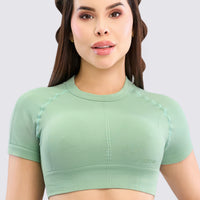 Top sin costuras color verde de diseño minimalista con banda de soporte y manga corta.