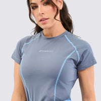 Camiseta deportiva color gris para mujer, con líneas de costura que hacen la diferencia. 