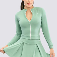 Chaqueta color verde con cierre frontal en colo blanco, de tacto suave y que se ajusta a la silueta brindando alto soporte. 

