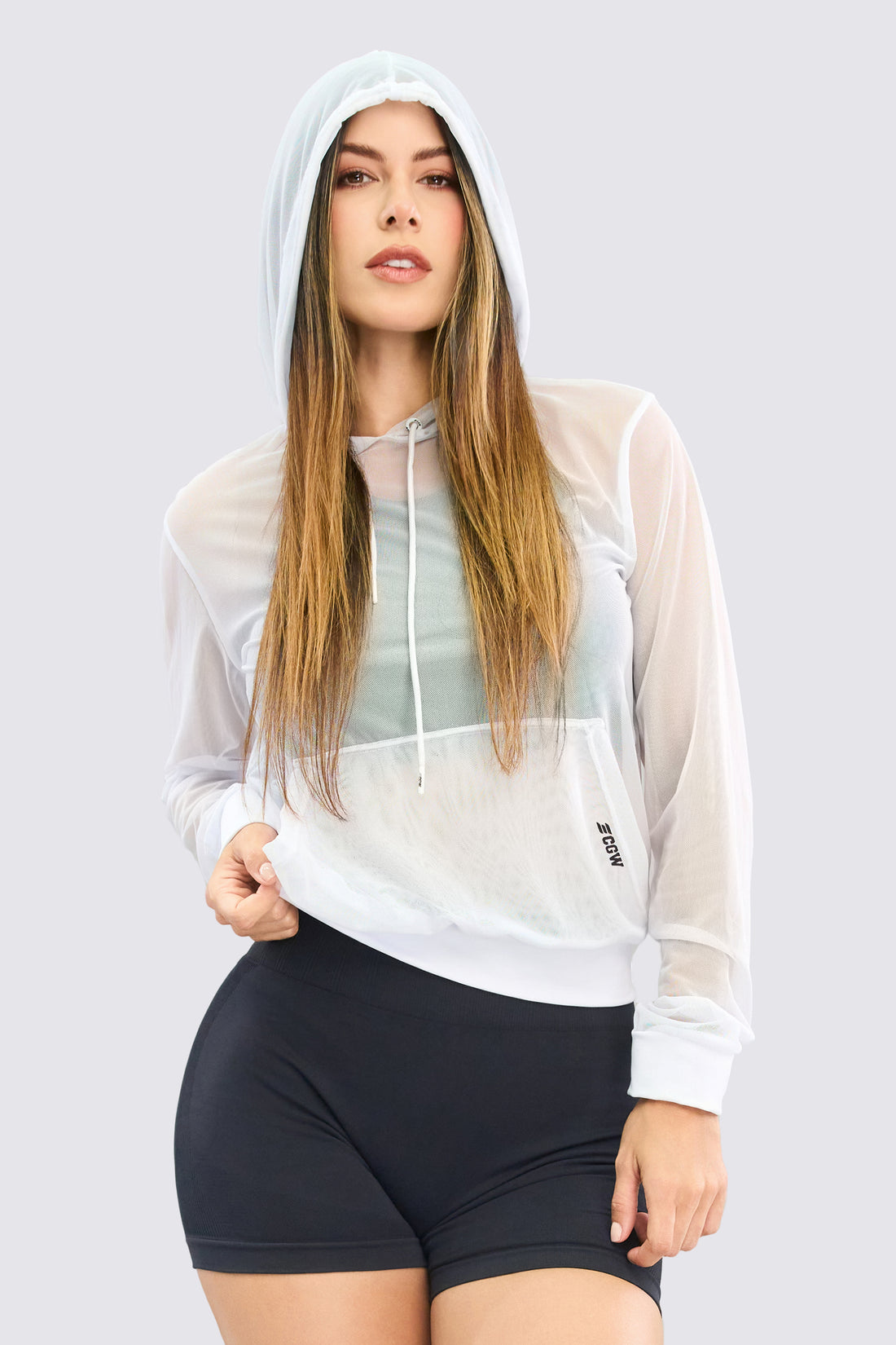 Buzo deportivo en malla, color blanco, con capucha, con cordón ajustable y textil transpirable. 