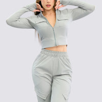 Chaqueta full zip, color gris, con bolsillos al frente y orificio en el pulgar.