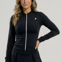 Chaqueta color negro con cierre frontal en blanco, ajuste al cuerpo. 