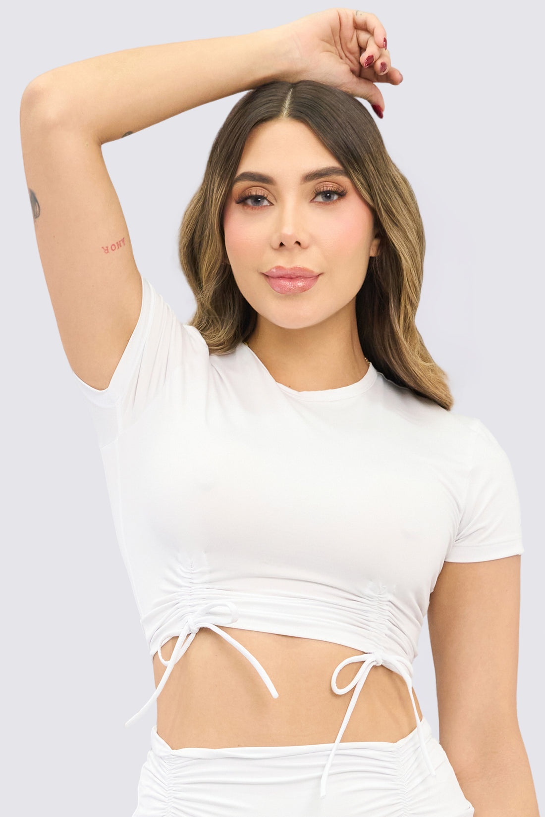 Top deportivo color blanco, con fruncido delantero, ajuste suave, y con libertad de movimiento. 