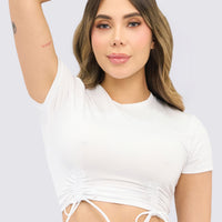Top deportivo color blanco, con fruncido delantero, ajuste suave, y con libertad de movimiento. 