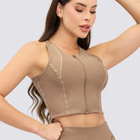 CropTop deportivo color mocca con cierre frontal y costuras que estilizan la figura. 