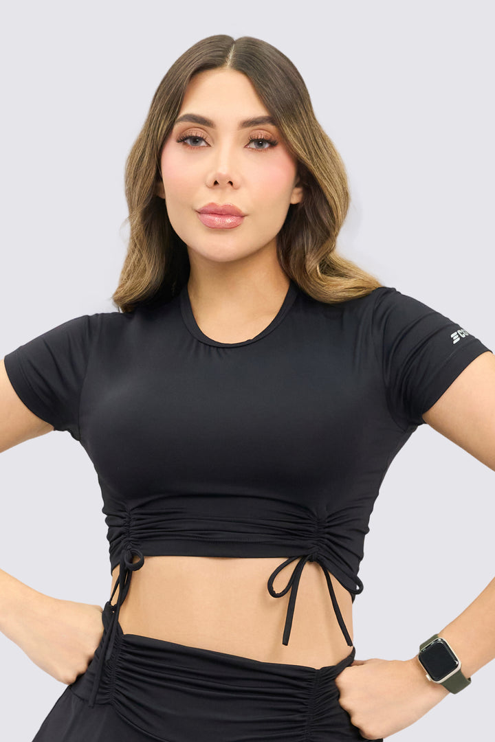 CropTop deportivo color negro, con fruncido delantero, ajuste perfecto y flexibilidad para cualquier actividad deportiva. 