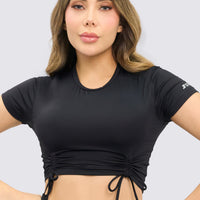 CropTop deportivo color negro, con fruncido delantero, ajuste perfecto y flexibilidad para cualquier actividad deportiva. 