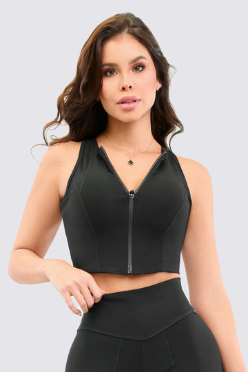 Crop Top deportivo color negro, con cierre delantero, y costuras estratégicas que estilizan la figura. 