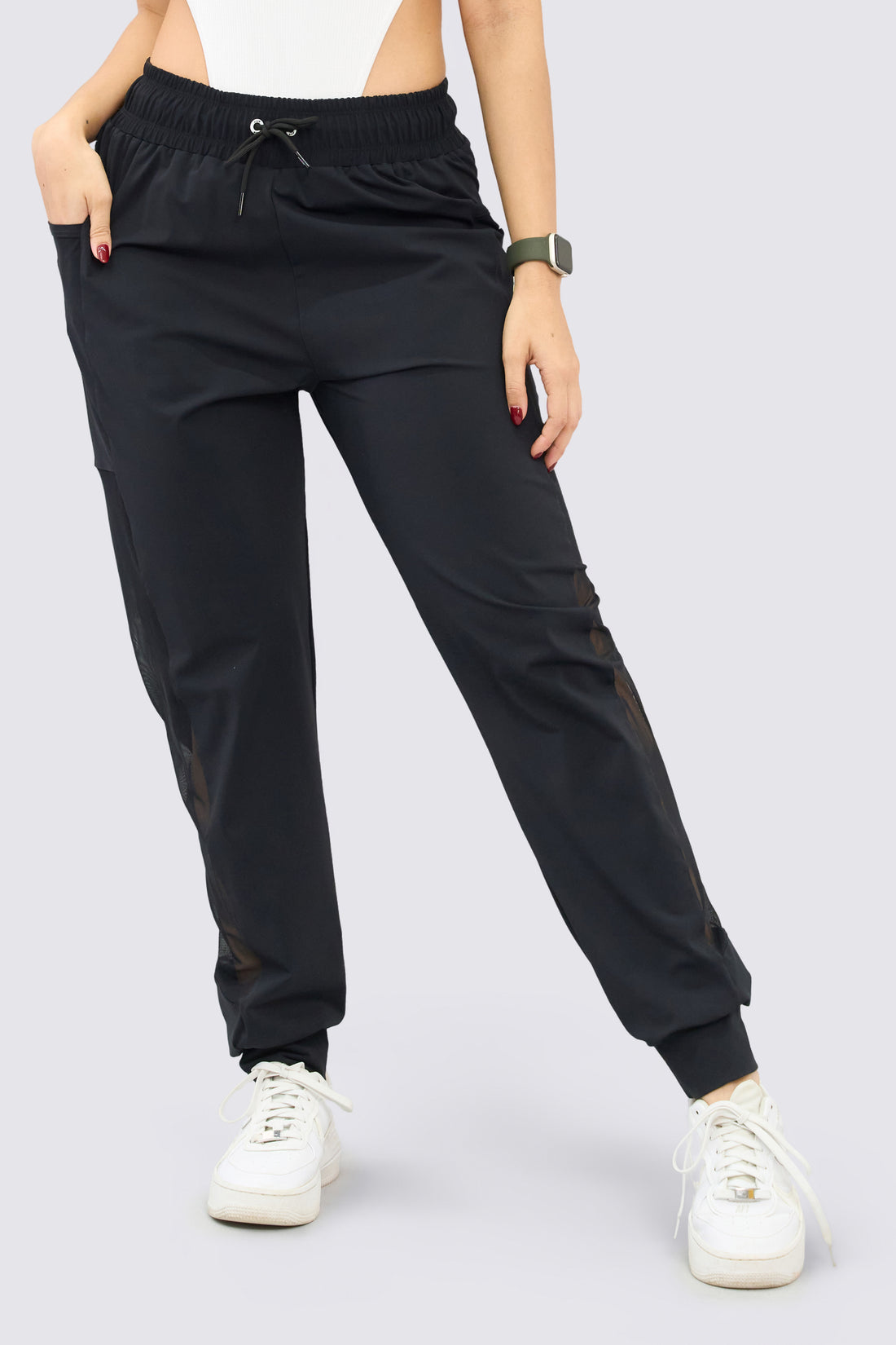 Jogger deportivo color negro, de tiro alto, pretina ajustable, mallas a los laterales y bolsillos funcionales. 