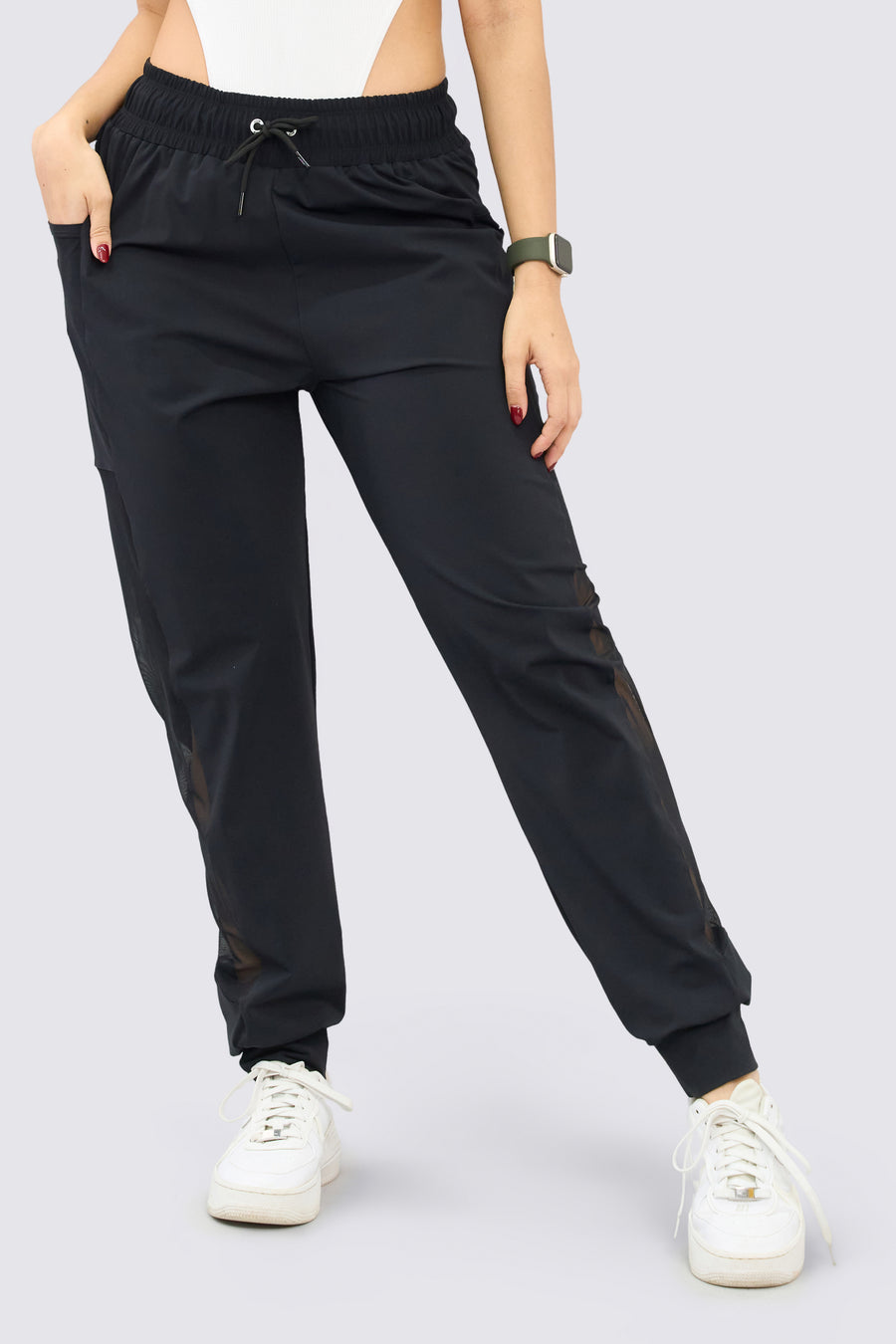 Jogger deportivo color negro, de tiro alto, pretina ajustable, mallas a los laterales y bolsillos funcionales. 