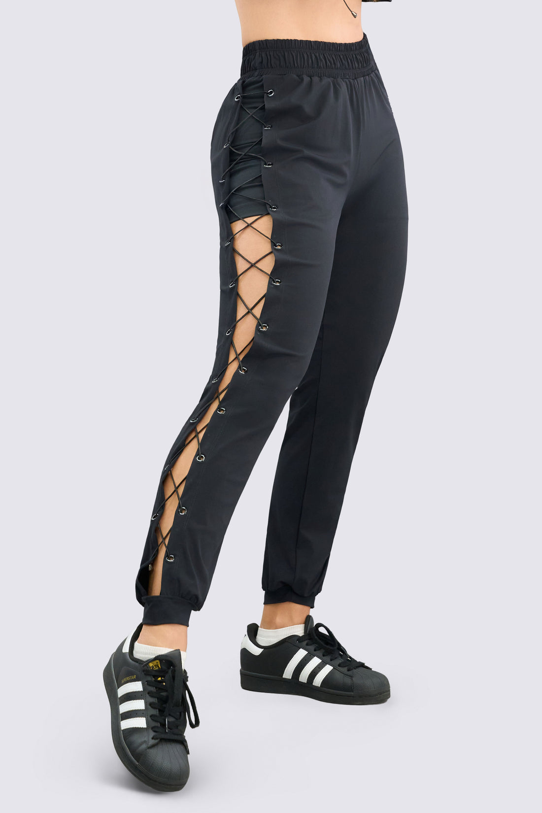 Jogger negro  deportivo de diseño atrevido con aberturas laterales y sistema de cordones ajustables que aportan un look moderno y diferenciador.