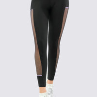 Leggings color negro, con mallas laterales y venas en color lila, con talle cruzado en V.