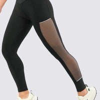 Leggings color negro, con malla, de talle alto cruzado en V.
