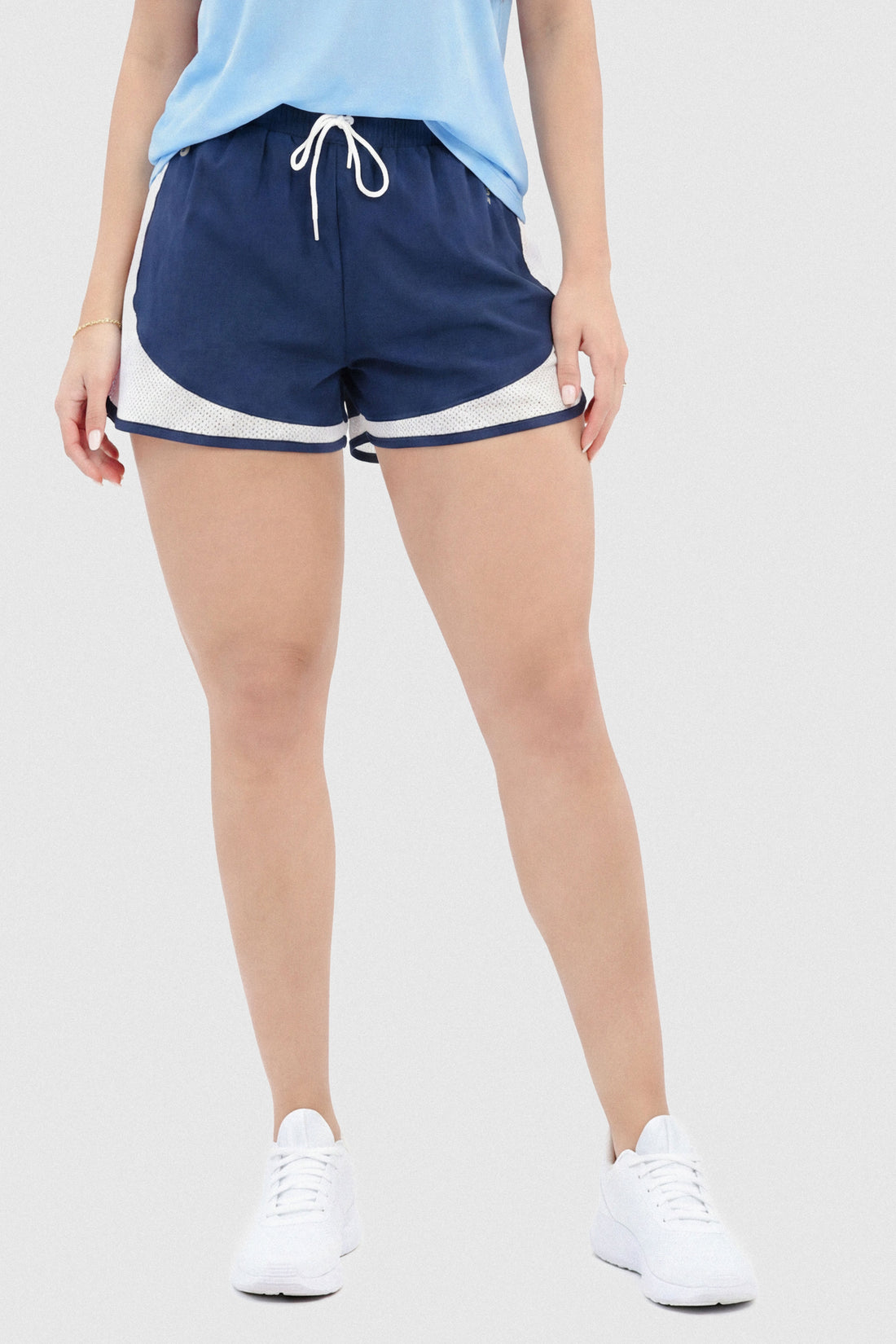 Pantaloneta azul profundo para mujer, con short interno y mallas laterales para mayor ventilación. 