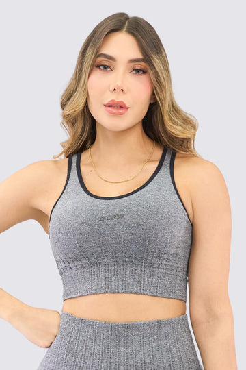 Top seamless deportivo de color negro, de alto soporte, costuras que crean textura. 