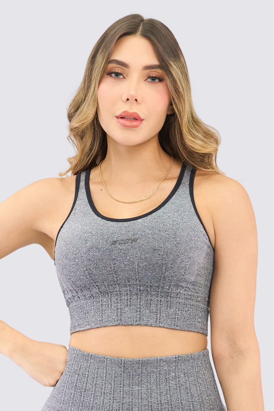 Top seamless deportivo de color negro, de alto soporte, costuras que crean textura. 