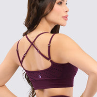 Top deportivo, con tirantes ajustables, patrón de líneas y puntos y alto soporte. 