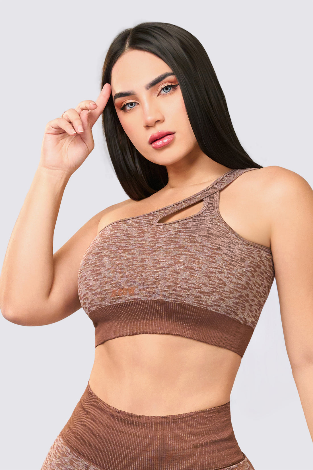 Top con escote asimétrico color café, y detalle cut out al frente, soporte medio y ajuste cómodo. 