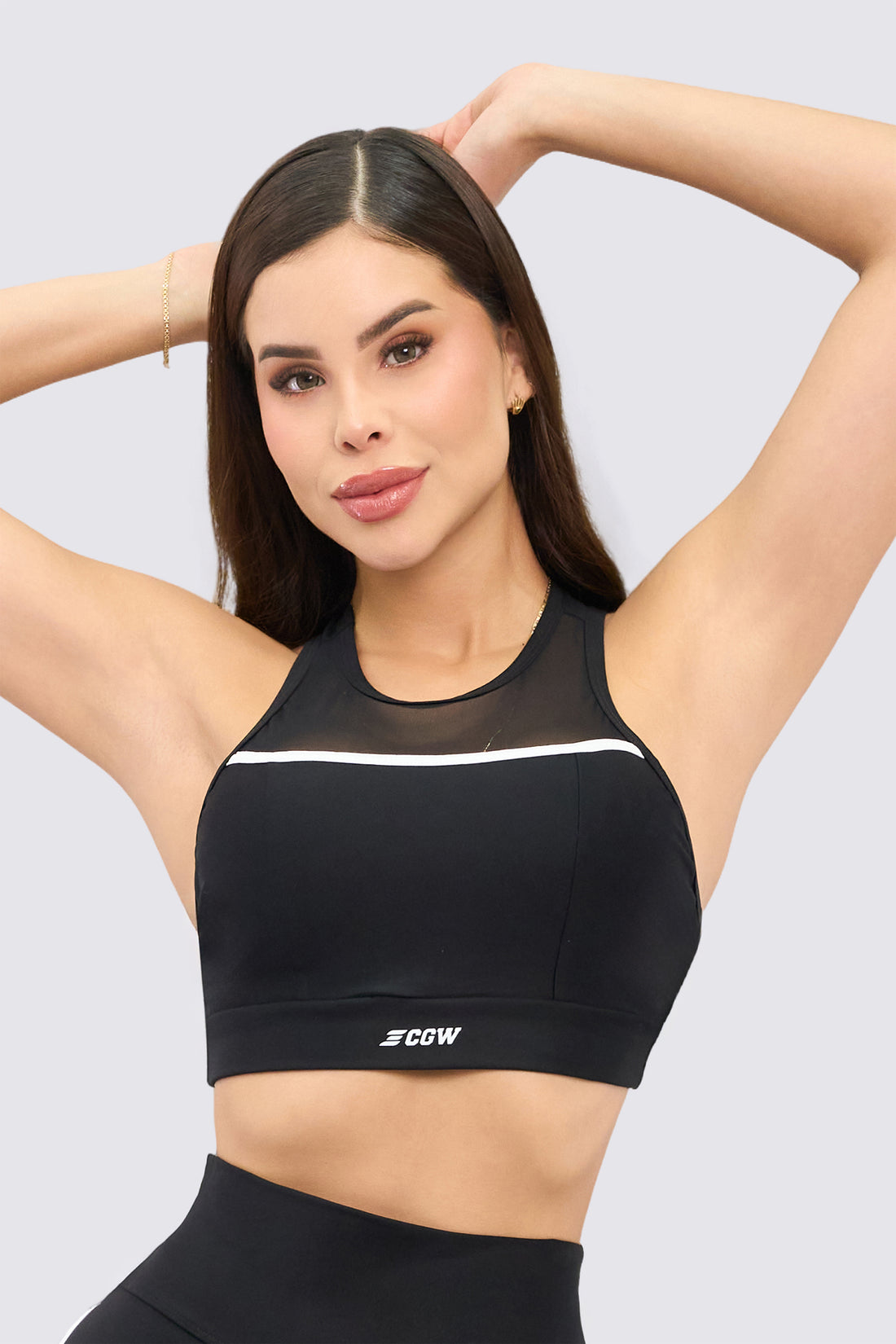 Top deportivo color negro con panel de malla frontal, vena color blanco y filtro solar. 