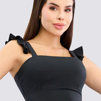 Top deportivo color negro, con tirantes de volantes, escote cuadrado y soporte medio. 